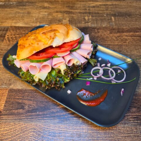 Ham and cheese sandwich with salad and seasonal vegetables