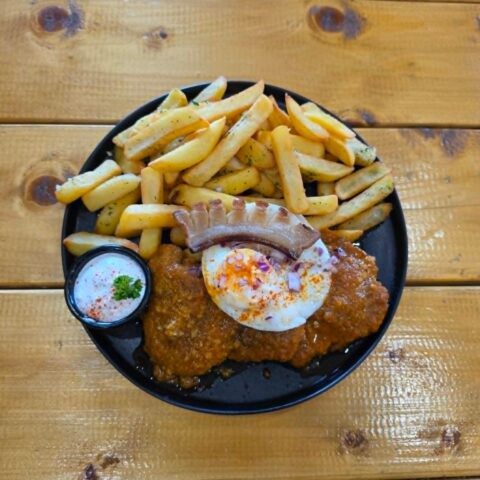 Gipsy style pork steak with fried egg smoked bacon and fries