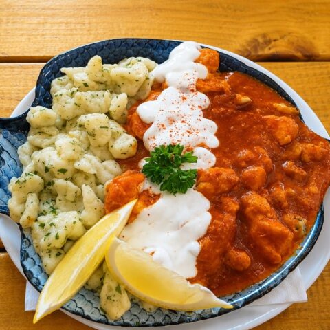 Hungarian fish paprikash with paprika sauce and homemade dumplings